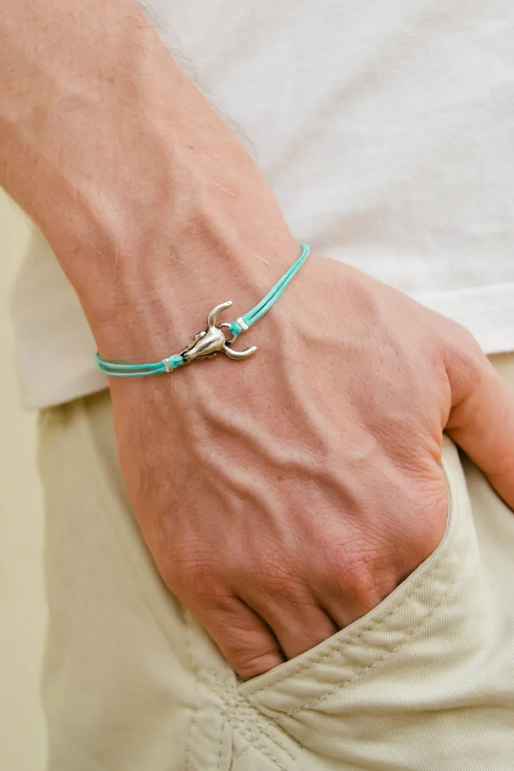 Men's bracelet with silver bull charm, turquoise cord, bull skull