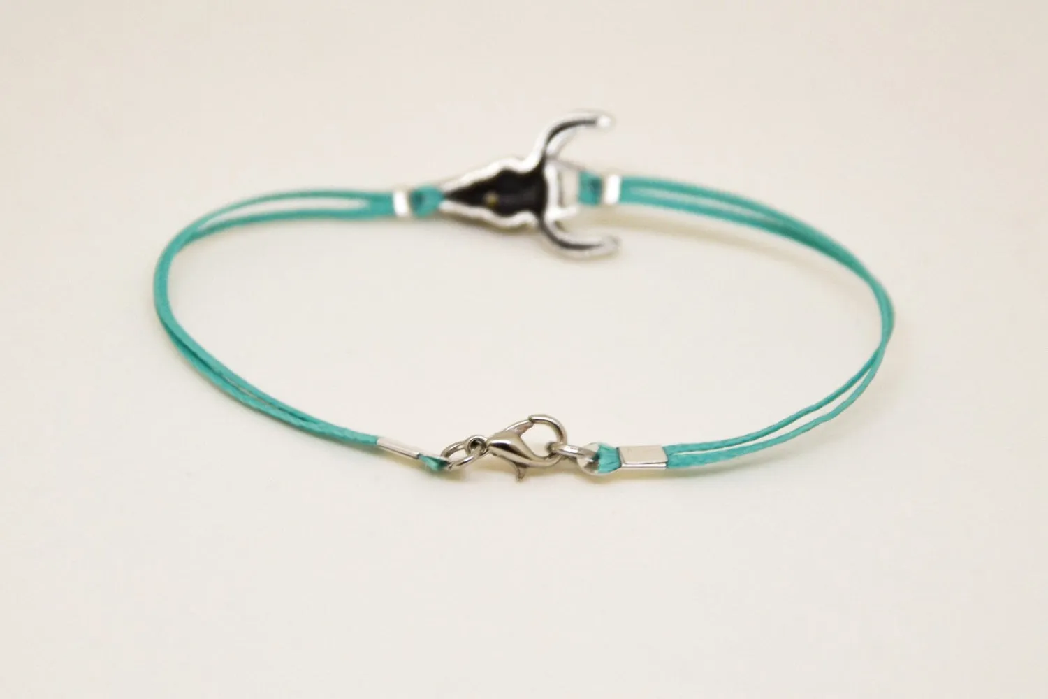 Men's bracelet with silver bull charm, turquoise cord, bull skull